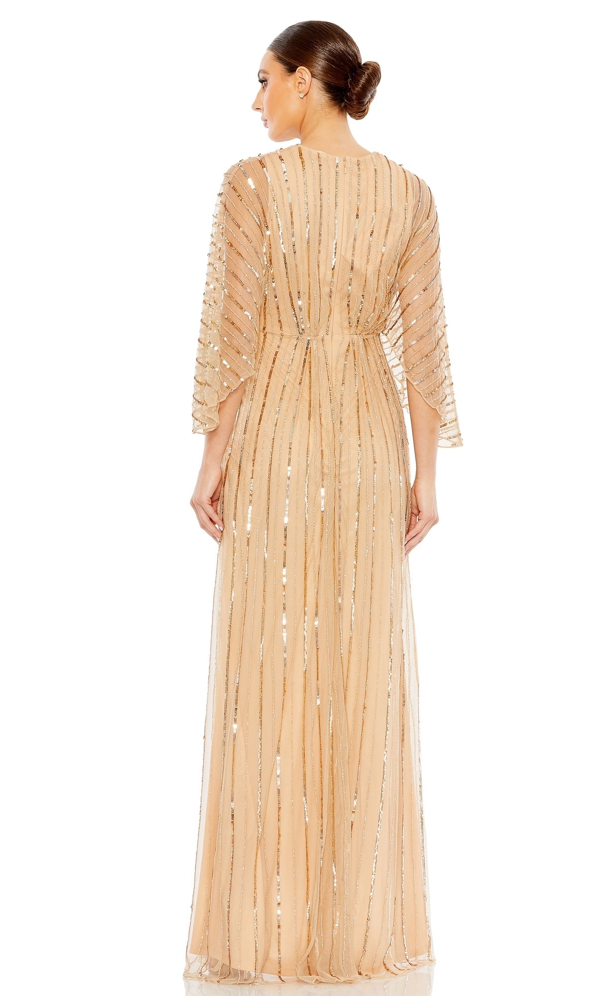 A woman stands facing away, wearing the Mac Duggal 93841 Long Sequin A-Line Formal Dress with vertical sequin embellishments and elbow-length sleeves. Her neat bun highlights the elegance of this evening gown.